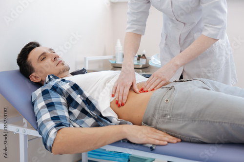 Photos Handsome nice man being examined by the doctor