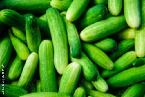 Blurred fresh green cucumber collection outdoor on market 