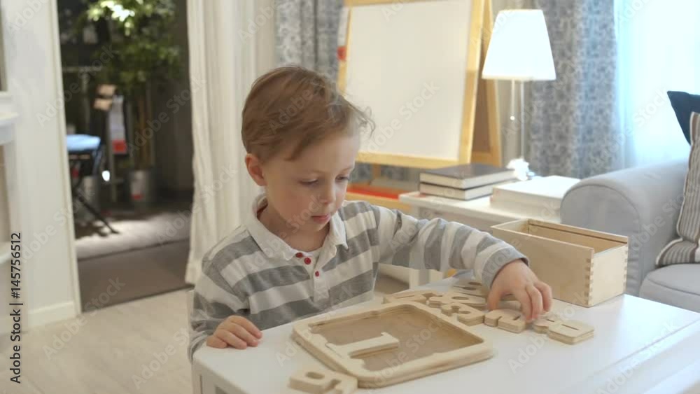 4 year old kid assembles a mosaic of figures in the room 4 year old kid assembles a mosaic of figures in the room
