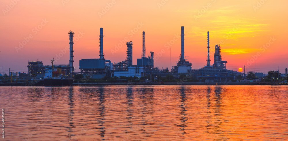 silhouette oil refinery industry at morning with golden sky.