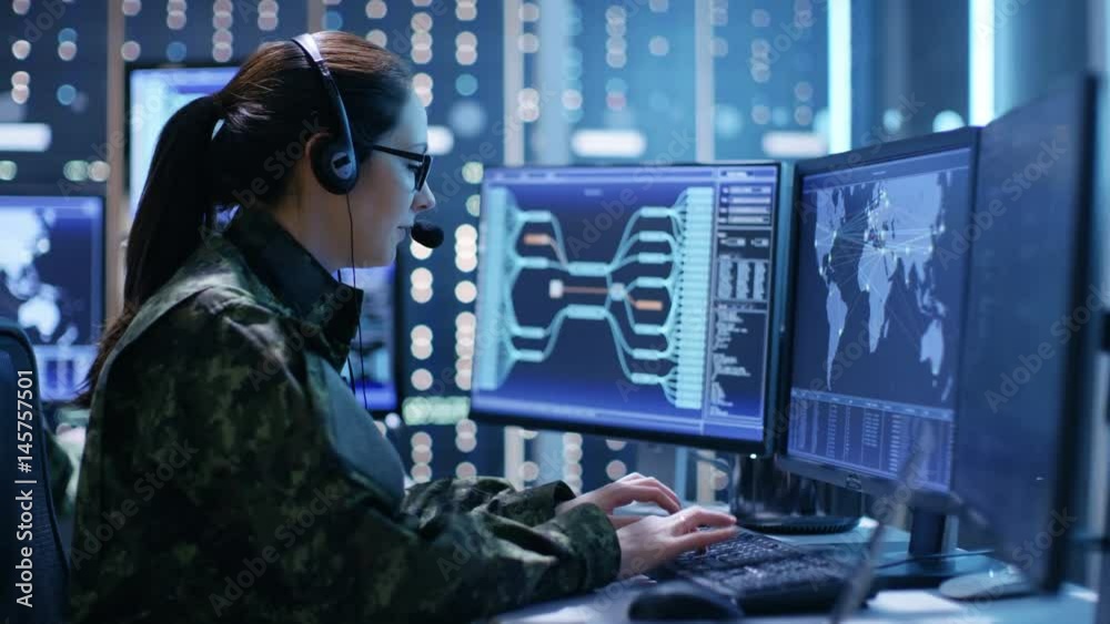 Female Military Technical Support Professional Gives Instructions into Headset. She's in a Monitoring Room with Many Working Screens.Shot on RED EPIC-W 8K Helium Cinema Camera.