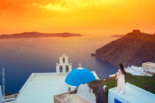 Brilliant sunset at Fira with a church and a bride on a roof  Santorini  Greece.