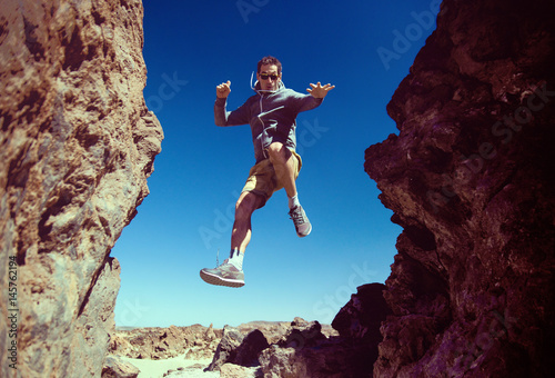 Cheerful man running on the desert mountains