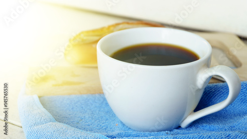 black coffee cup without sugar and fresh bread baked on white wood background