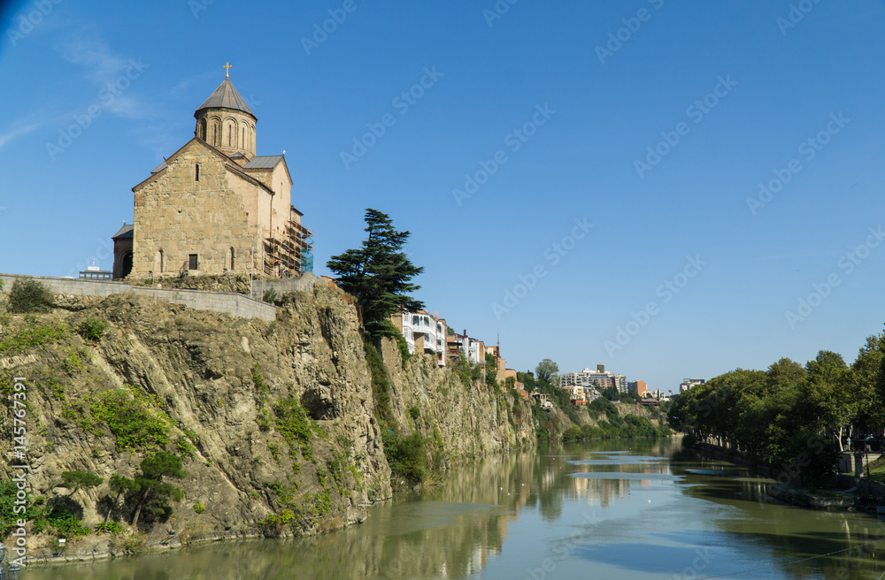 View of the Metekhis Cathedral above Kura river in Tbilisi city center, Georgia