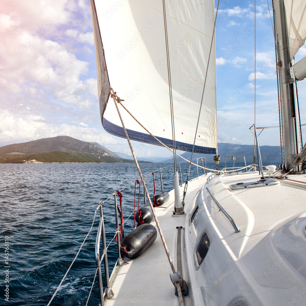 Obraz premium Front part of a sailboat, set on full sails to the sea