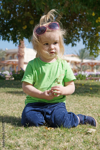 small baby boy with adorable face on green grass