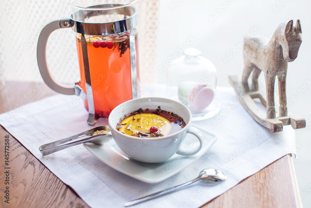 Hot tea with cranberries and herbs in a French press Hot tea with cranberries and herbs in a French press