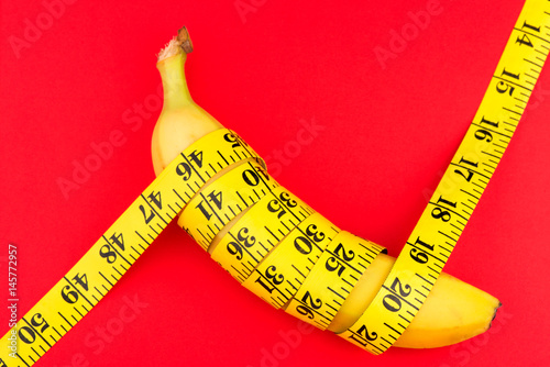 a banana and a centimeter on a red background