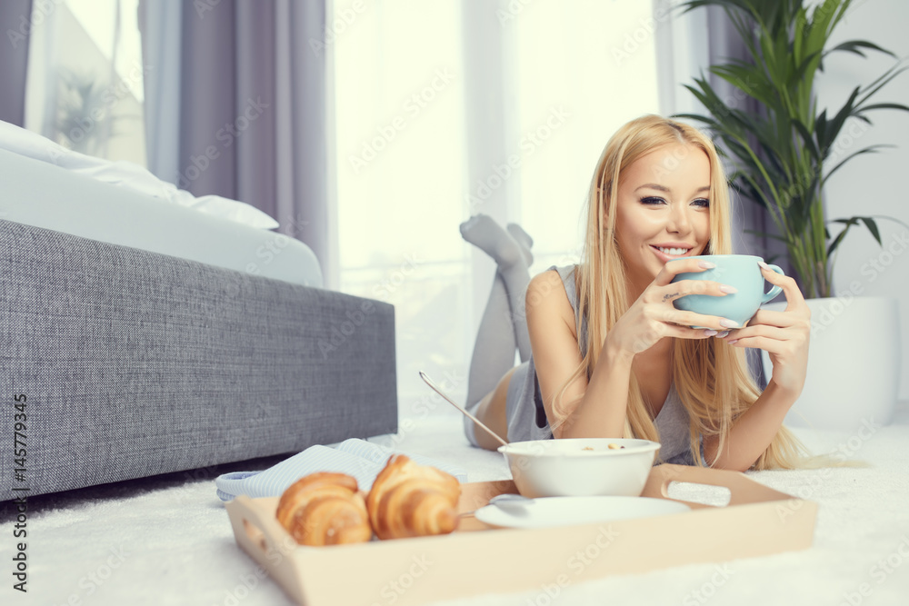Young beautiful woman having breakfast in bed. Young beautiful woman having breakfast in bed.