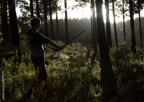 Boy with sword in forest - early morning