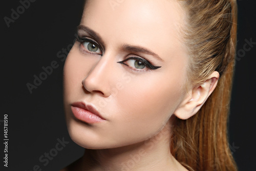 Beautiful young girl face on color background