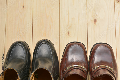 Male and female leather shoes on wooden background