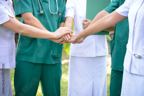 Doctors surgeon and nurses in a medical team stacking hands