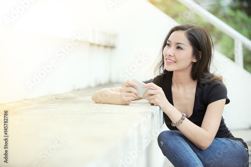 Portrait of young hipster woman sitting at using mobile smart phone