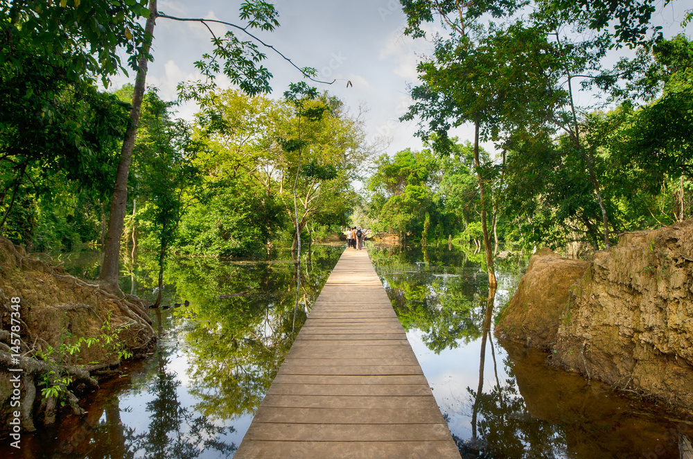 Fototapeta premium The wooden path towards to Neak Pean temple on artificial island. Angkor.