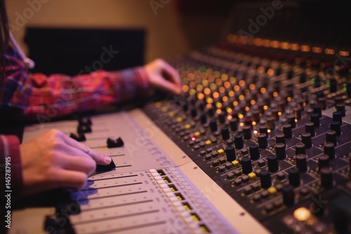 Hands of female audio engineer using sound mixer photo