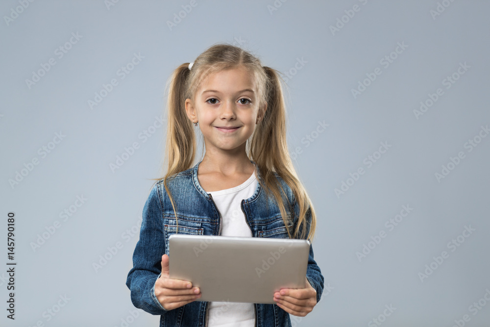 Little Teenage Girl Using Tablet Computer, Small Kid Happy Smiling Child Isolated Over Gray Background Little Teenage Girl Using Tablet Computer, Small Kid Happy Smiling Child Isolated Over Gray Background