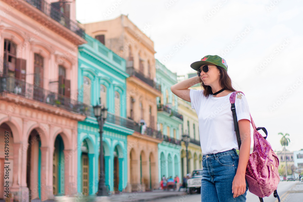 Happy woman in popular area in old Havana, Cuba. Young girltraveler smiling happy background colorful houses