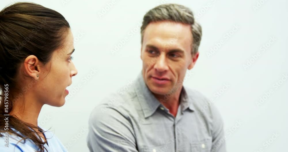 Dentist discussing over digital tablet with male patient Dentist discussing over digital tablet with male patient