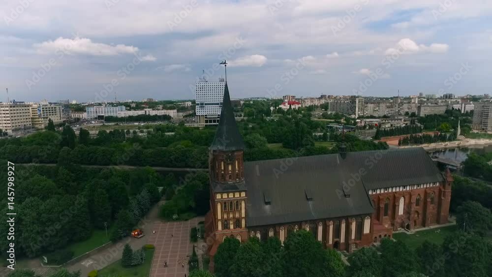 Kaliningrad. Historical Part of City. Red Brick Castle. Green Park by River. Town Buildings on Background. Clouds on Sky Kaliningrad. Historical Part of City. Red Brick Castle. Green Park by River. Town Buildings on Background. Clouds on Sky
