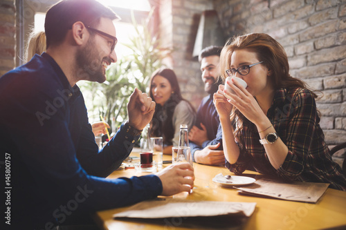 Colleagues from work socializing in restaurant and eating together