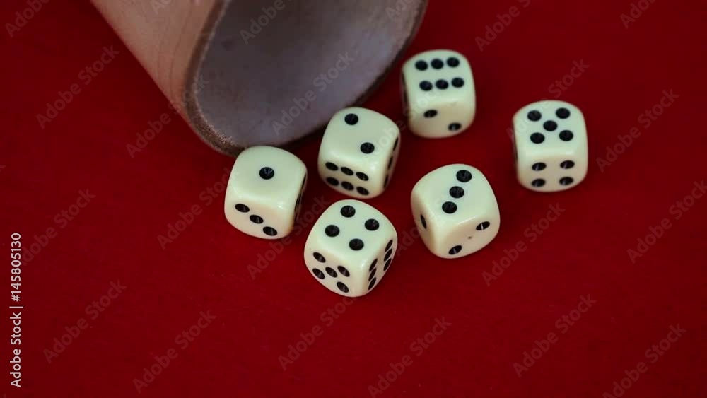 six dice with cup on red rotating table
six dice with cup on red rotating table