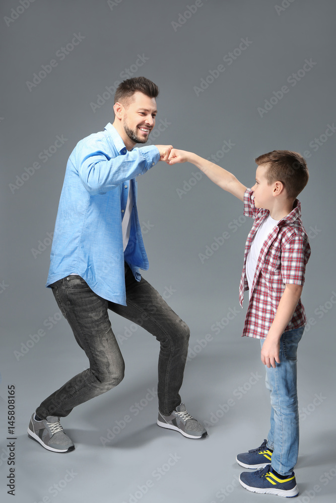 Father and son having fun on color background Father and son having fun on color background