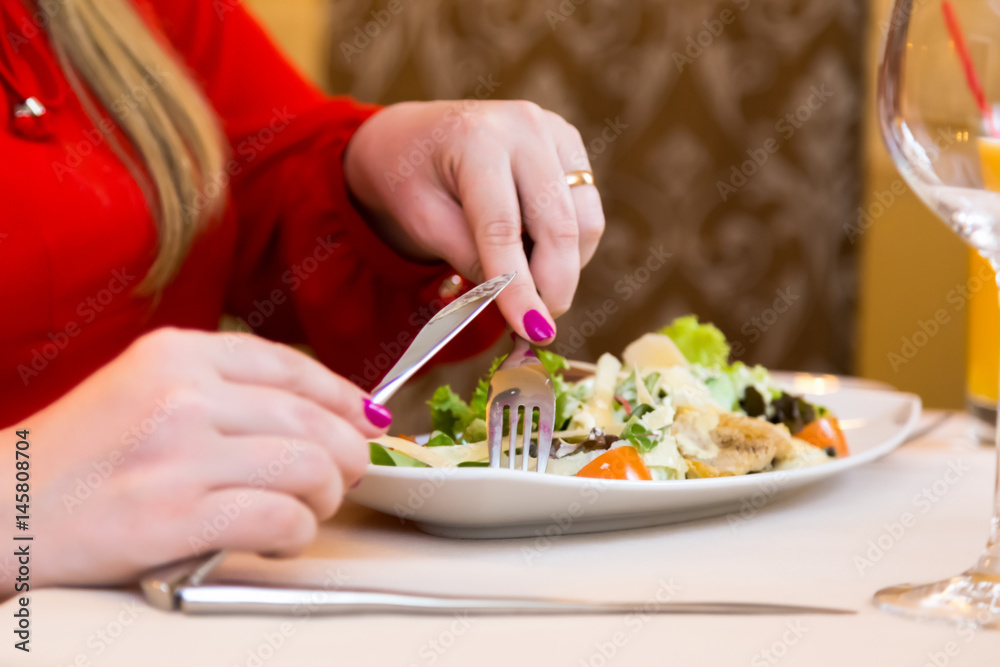 Woman in red eats salad natural. Healthy eating and diet