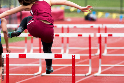 High School Girls Track hurdle race from behind