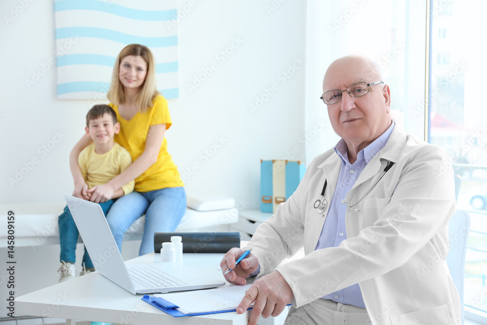 Fototapeta premium Elderly orthopedist with patients in his office