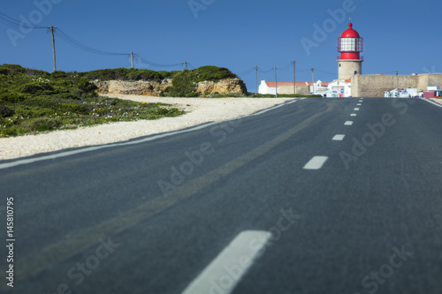 road guides to lighthouse under sky