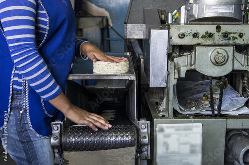 mujer en maquina tortilladora