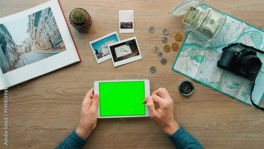 Young man hands searching something on tablet on wood background. Top view. Chroma key. Young man hands searching something on tablet on wood background. Top view. Chroma key.