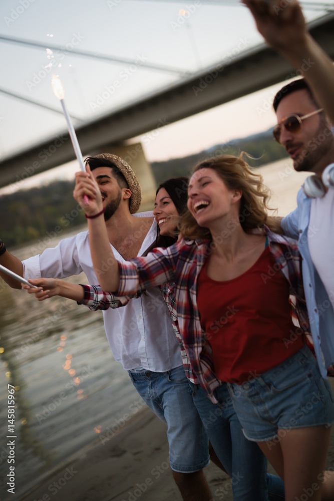 Naklejka premium Group of happy friends partying on beach