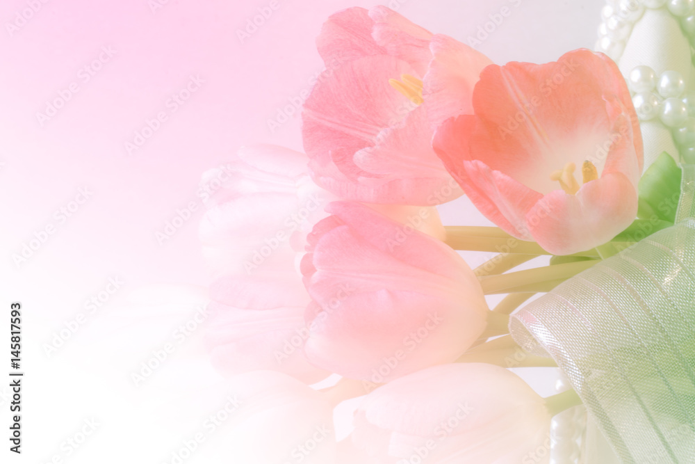 fresh pink lilies on wicker basket decorate pearl and ribbon. Closeup and soft background