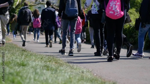 Crowd of people walking through park, slow motion