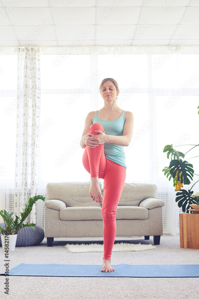 Good-looking sportswoman in tights balancing on one leg Good-looking sportswoman in tights balancing on one leg