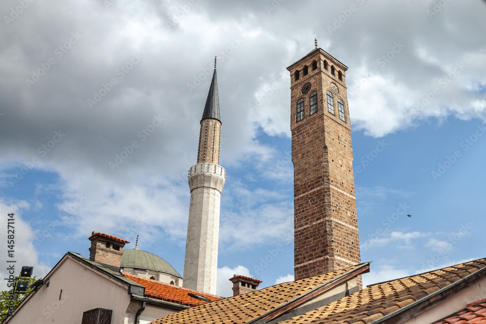 Minaert of the Gazi Husrev begova Mosque next to the clocktower of Sarajevo bazaar, in Bosnia and Herzegovina.