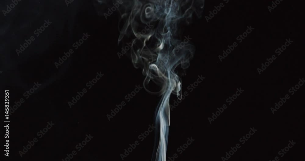 Detail of smoke columns from cigarettes against black background Detail of smoke columns from cigarettes against black background