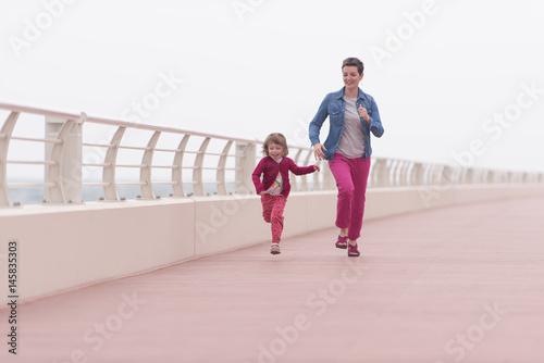 mother and cute little girl on the promenade by the sea