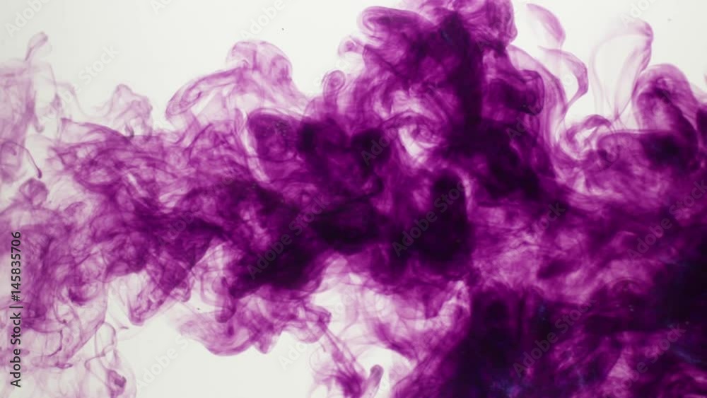 Purple dye expands into a cloud in clear water over a white BG. Slow motion. Purple dye expands into a cloud in clear water over a white BG. Slow motion.