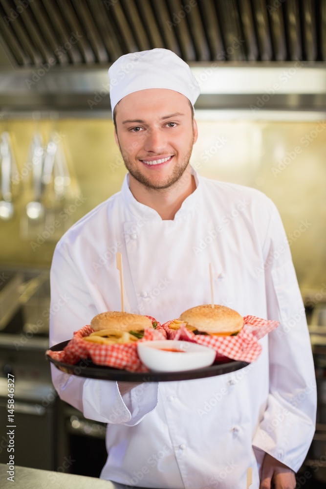 Professional chef holding burgers in plate Professional chef holding burgers in plate