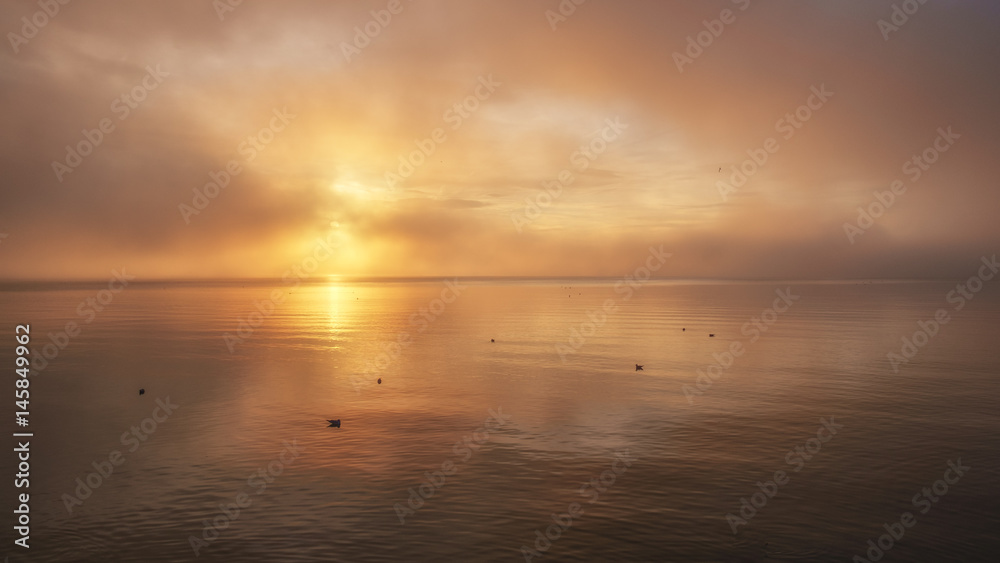 misty sunset and reflections on water