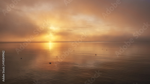 misty sunset and reflections on water