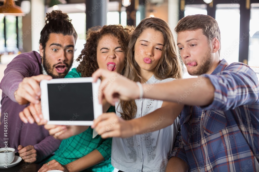 Playful friends taking selfie with digital tablet Playful friends taking selfie with digital tablet