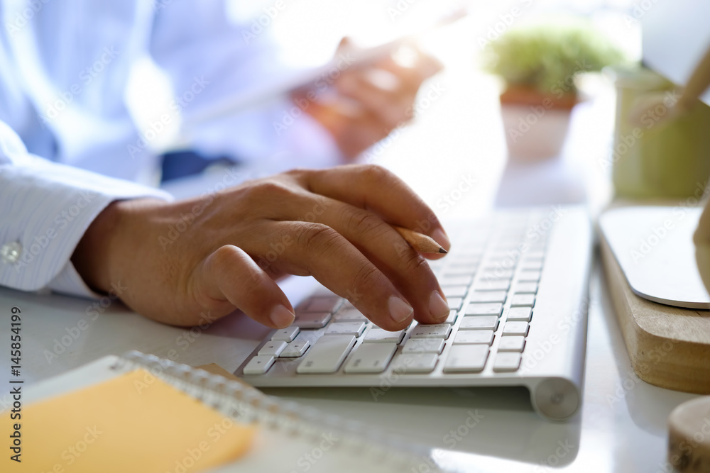 Businessman typing or working with modern desktop computer on white desk work table at office. Businessman typing or working with modern desktop computer on white desk work table at office.