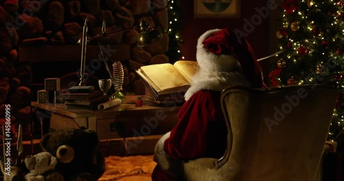 Zoom in on Santa adjusting Naughty/Nice List with quill in North Pole