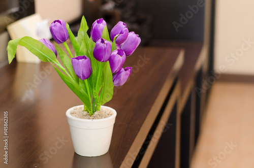 Artificial purple tulips in jar.