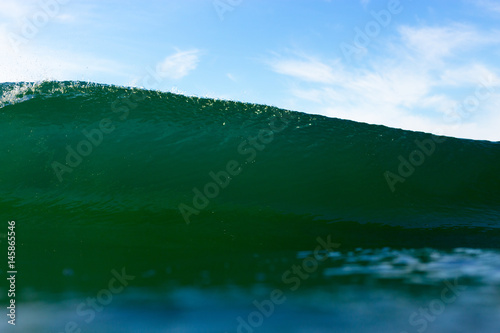 Fototapeta Naklejka Na Ścianę i Meble -  An abstract water angle of an emerald, powerful breaking wave on a bright summer day.